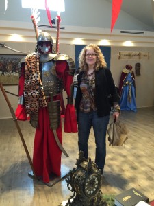 The author stands next to a statue of an armored Polish hussar (elite cavalry)